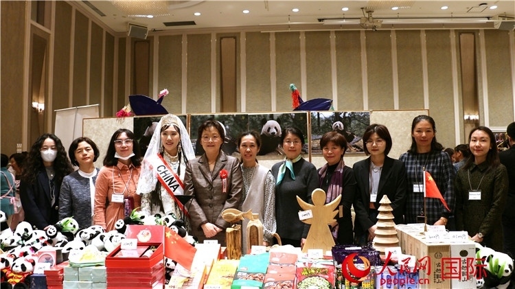 中國駐日本大使吳江浩夫人丁玥(左五)與使館人員在展位前合影留念。人民網 許可攝