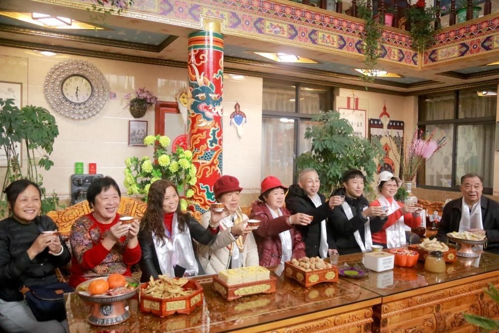 游客們?nèi)胱∶袼藓?，舉杯共飲酥油茶。新華社記者 邱星翔 攝