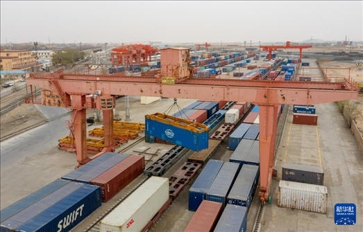 4月21日，二連浩特鐵路口岸龍門吊吊裝中歐班列集裝箱（無人機(jī)照片）。 新華社發(fā)（張海峰攝）