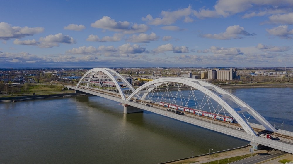 2024年3月12日，一列火車運(yùn)行在匈塞鐵路塞爾維亞境內(nèi)貝諾段諾維薩德多瑙河大橋上（無(wú)人機(jī)照片）。新華社發(fā)（任衛(wèi)云攝）