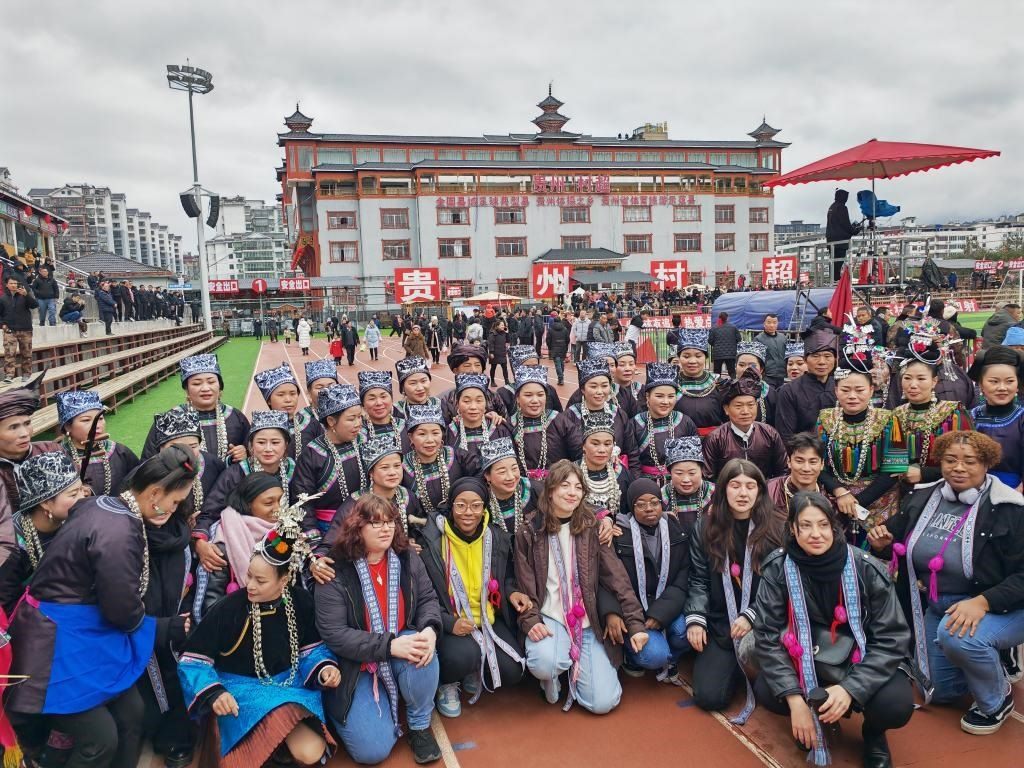 法國青年在“村超”賽場邊與參加表演的村民合影。新華社記者 羅羽 攝