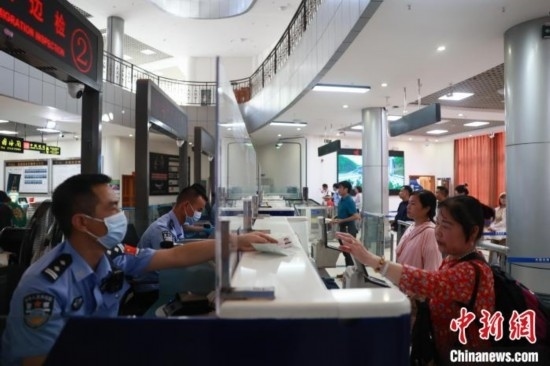 圖為旅客在磨憨口岸辦理通關手續(xù)。雷雨 攝