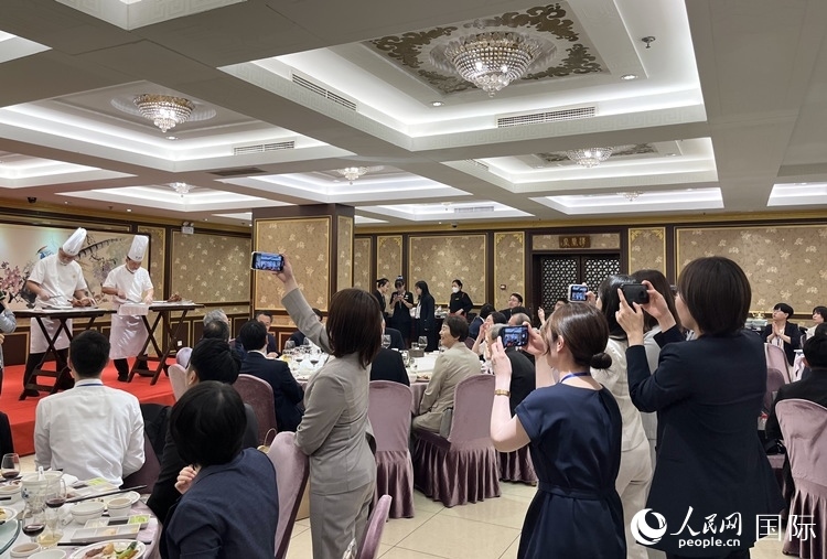 國(guó)家級(jí)非物質(zhì)文化遺產(chǎn)、全聚德片鴨工藝吸引代表團(tuán)成員拍照留念。