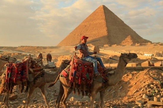1月24日，商販騎駱駝離開埃及吉薩金字塔景區(qū)。新華社記者 隋先凱 攝