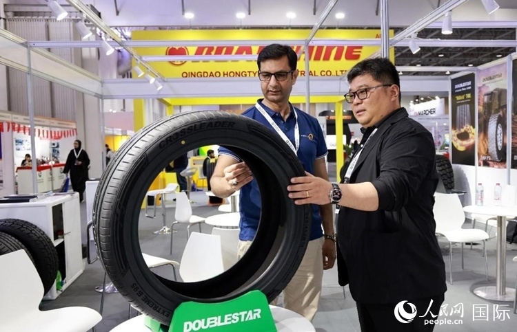 工作人員向客戶展示雙星電動汽車輪胎。和傳統(tǒng)汽車輪胎相比，電動汽車輪胎具有更高承載能力、更加靜音舒適、更好極速抓地、更低滾動阻力等特點。人民網(wǎng)記者 管克江攝