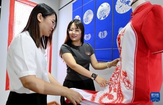 5月31日，在衡水市阜城縣一家剪紙工作室，游客在觀賞帶有剪紙元素的旗袍。