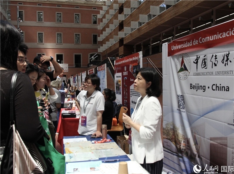 旅西華人華僑在展臺前咨詢。人民網(wǎng)記者 許海林?jǐn)z