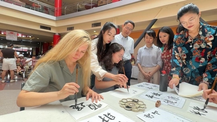 羅馬尼亞友人在活動(dòng)現(xiàn)場(chǎng)學(xué)寫(xiě)漢字。中國(guó)駐羅馬尼亞大使館領(lǐng)僑處供圖