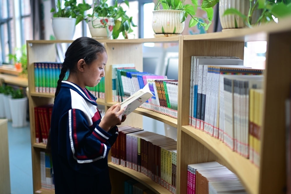 6月18日，果洛西寧民族中學學生尼東拉毛在圖書室看書。