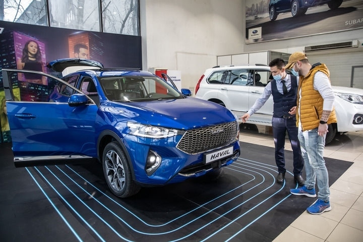 2021年4月1日，銷售人員在哈薩克斯坦阿拉木圖市經(jīng)銷商店向消費(fèi)者介紹哈弗汽車。新華社發(fā)（阿斯塔納汽車公司供圖）
