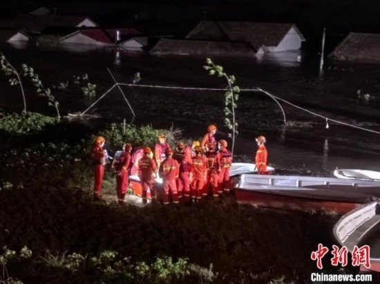  7月6日凌晨3時(shí)，在湖南岳陽華容縣團(tuán)洲垸洞庭湖一線堤防，救援人員剛剛完成一次救援任務(wù)，遠(yuǎn)處是被淹的民房。中新社記者 白祖偕 攝