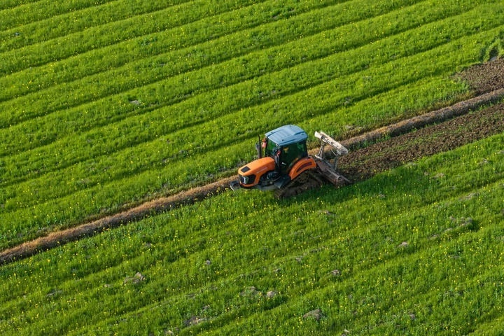 2024年3月19日，在湖南省常德市鼎城區(qū)謝家鋪鎮(zhèn)港中坪村，村民駕駛農(nóng)機(jī)翻耕田地（無人機(jī)照片）。新華社記者 陳思汗 攝