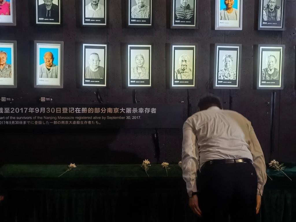 7月18日，人們向離世的南京大屠殺幸存者獻(xiàn)花、鞠躬。新華社記者邱冰清 攝