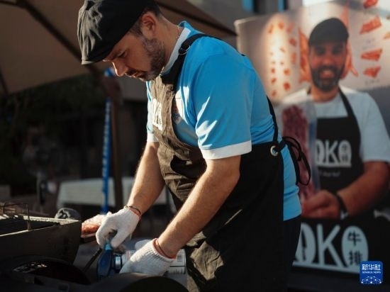 7月19日，在蕪湖古城，馬丁在當(dāng)天舉行的啤酒節(jié)上制作牛排。新華社發(fā)（繆雨晨 攝）