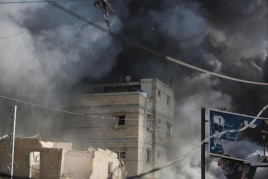 7月21日，在加沙地帶中部的努賽賴特難民營(yíng)，遭以軍空襲的建筑冒出滾滾濃煙。新華社發(fā)（馬爾萬(wàn)·達(dá)烏德攝）