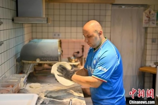 近日，韋榮耀在自家披薩小店內(nèi)忙活。俞靖 攝