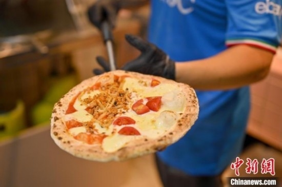 近日，韋榮耀展示他制作的“老友味”披薩。 俞靖 攝