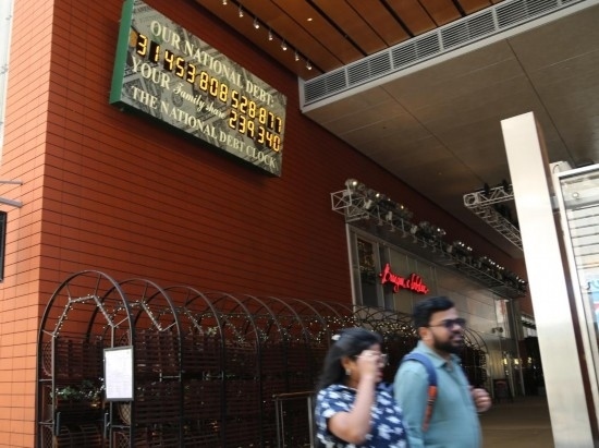 2023年5月29日，人們經(jīng)過(guò)美國(guó)紐約曼哈頓的“國(guó)債鐘”。“國(guó)債鐘”是一個(gè)大型計(jì)數(shù)器，它實(shí)時(shí)更新美國(guó)的公共債務(wù)總額，并顯示出每個(gè)美國(guó)家庭所要負(fù)擔(dān)的數(shù)額。 新華社記者劉亞南攝