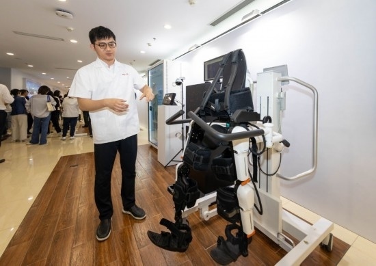2024年5月24日，在位于上海市嘉定區(qū)的上海交通大學(xué)醫(yī)學(xué)院附屬瑞金醫(yī)院腫瘤質(zhì)子中心，工作人員介紹由瑞金醫(yī)院醫(yī)生和醫(yī)療公司共同研發(fā)的用于恢復(fù)患者下肢的醫(yī)療機(jī)器人。新華社記者 王翔 攝
