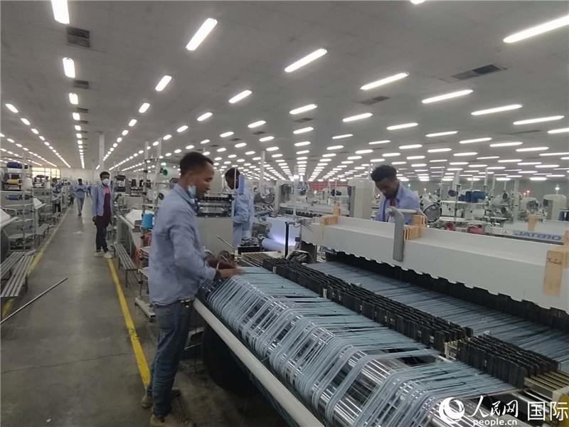 無錫金茂埃塞面料廠車間內(nèi)，當?shù)毓と苏谝唤z不茍地作業(yè)。人民網(wǎng)記者 黃培昭攝