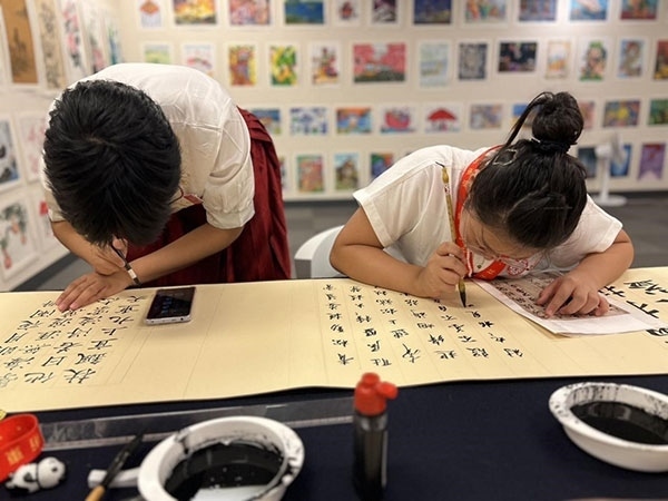 參加本次展覽的青少年在現(xiàn)場進(jìn)行書法創(chuàng)作。主辦方供圖