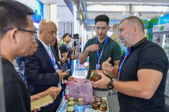 2023年8月23日，在第十四屆中國—東北亞博覽會東北亞商品館，俄羅斯參展商向參觀者介紹商品。