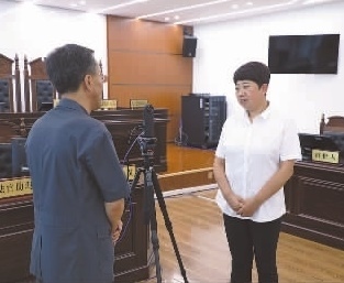 圖為全國(guó)人大代表玉明姬(右)詳細(xì)了解環(huán)境資源審判工作情況。劉思妤 攝