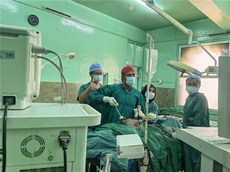 隊長蔣國慶（左一）關注當?shù)蒯t(yī)生手術(shù)情況。中國援桑醫(yī)療隊供圖