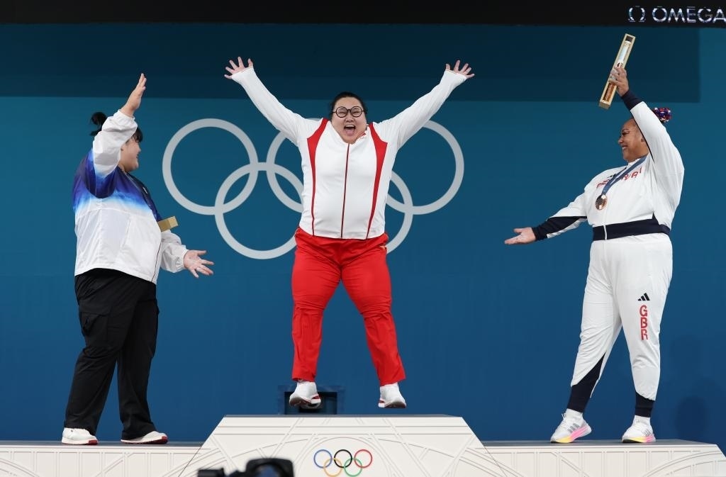 中國選手李雯雯（中）在巴黎奧運(yùn)會(huì)舉重女子81公斤以上級(jí)頒獎(jiǎng)儀式中登上領(lǐng)獎(jiǎng)臺(tái)（2024年8月11日攝）。新華社記者 楊磊 攝