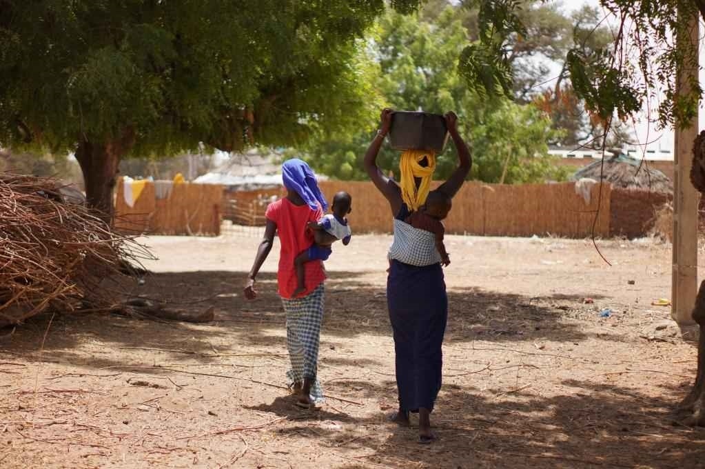 2023年3月20日，在塞內(nèi)加爾久爾貝勒區(qū)的泰內(nèi)富勒村，村民將取到的水運(yùn)回家。新華社記者 王子正 攝