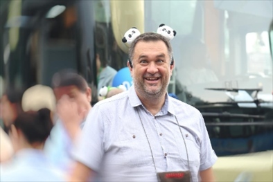 參訪熊貓谷前，塞爾維亞“一帶一路”研究所所長博揚·拉利奇戴上熊貓頭飾。（李佩藺 攝）