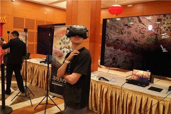 1、在本次活動(dòng)的展覽現(xiàn)場(chǎng)，敦煌研究院與騰訊展示了“數(shù)字藏經(jīng)洞”和“尋境敦煌”等創(chuàng)新互動(dòng)產(chǎn)品。圖為當(dāng)?shù)孛癖娡ㄟ^(guò)VR虛擬游覽洞窟。 人民網(wǎng)記者 李志偉攝
