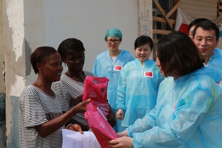 2015年4月4日，在位于塞拉利昂首都弗里敦市郊的中塞友好醫(yī)院埃博拉診療中心，中國第四批援塞醫(yī)療隊副隊長邵蔚（右前）向被治愈的埃博拉出血熱患者贈送禮物。新華社發(fā)（祖榮強 攝）