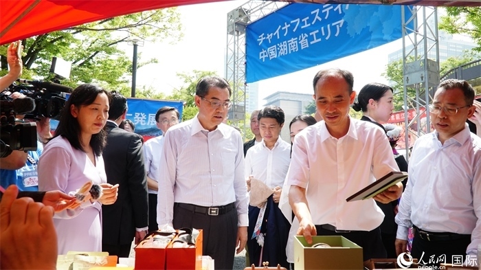 湖南展位工作人員向中國(guó)駐日本大使吳江浩介紹特色文創(chuàng)產(chǎn)品。人民網(wǎng) 蔣曉辰攝