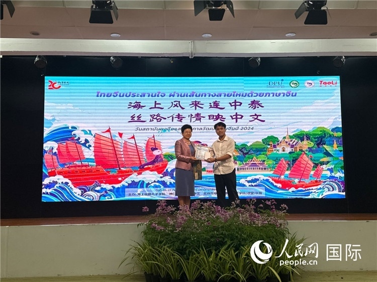 中國(guó)駐泰國(guó)大使館一等秘書(shū)王歡（左）為一等獎(jiǎng)獲獎(jiǎng)?wù)哳C獎(jiǎng)