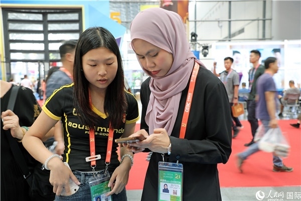 東博會現(xiàn)場，馬來西亞展商在同中方工作人員交談。人民網(wǎng)記者 趙益普攝