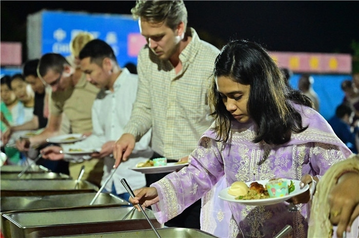 外國(guó)友人品嘗中國(guó)美食。馬騫攝