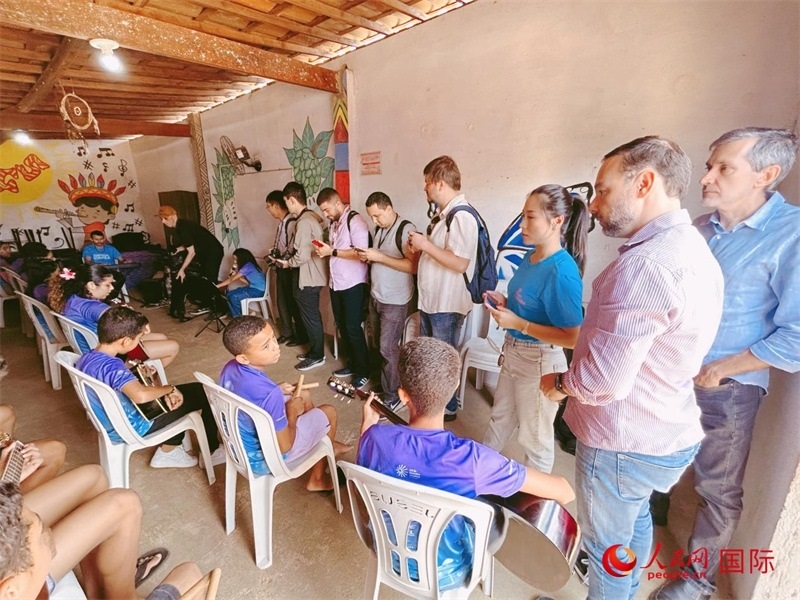  受益于中國企業(yè)的“青少年成長”項目，700多名當?shù)厍嗌倌甑囊魳泛妥闱驂粝氩迳狭顺岚?。圖為聯(lián)合采訪團正在采訪參加音樂培訓的孩子們。 人民網(wǎng)記者 陳一鳴攝