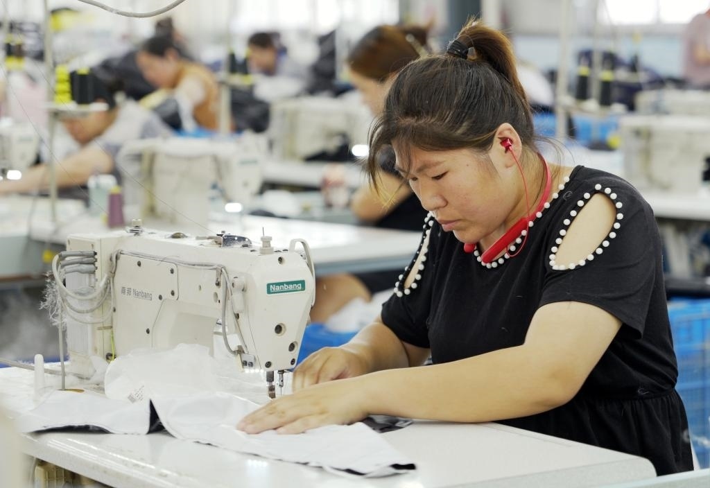 5月20日，村民在李寨村服裝加工廠內(nèi)忙碌。河南省周口市沈丘縣馮營鎮(zhèn)李寨村地處豫東平原。近年來，乘著脫貧攻堅(jiān)與鄉(xiāng)村振興政策的東風(fēng)，李寨村積極探索產(chǎn)業(yè)發(fā)展模式，通過“龍頭企業(yè)+村集體經(jīng)濟(jì)+農(nóng)戶”的方式，逐漸發(fā)展形成肉牛養(yǎng)殖、設(shè)施農(nóng)業(yè)、服裝加工、康養(yǎng)民宿等產(chǎn)業(yè)，以產(chǎn)業(yè)振興助力鄉(xiāng)村振興。新華社記者 李嘉南 攝