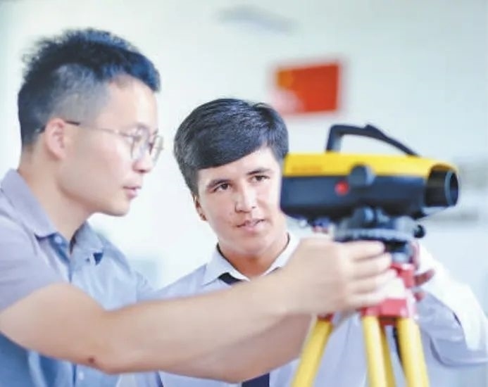 在塔吉克斯坦首都杜尚別的魯班工坊，來(lái)自天津城市建設(shè)管理職業(yè)技術(shù)學(xué)院的老師（左）為當(dāng)?shù)貙W(xué)生提供指導(dǎo)。新華社記者 鄭開(kāi)君 攝