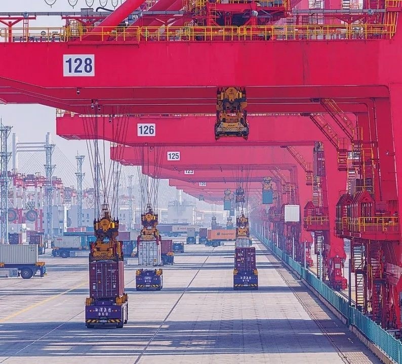 共建“一帶一路”國(guó)家在工作制度對(duì)接、技術(shù)標(biāo)準(zhǔn)協(xié)調(diào)、檢驗(yàn)結(jié)果互認(rèn)等方面強(qiáng)化合作、統(tǒng)一標(biāo)準(zhǔn)，貿(mào)易自由化便利化水平不斷提升。上海洋山港海關(guān)對(duì)接共建國(guó)家進(jìn)出口貨物相關(guān)標(biāo)準(zhǔn)，推動(dòng)通關(guān)一體化方式申報(bào)，提升通關(guān)效率。圖為無(wú)人駕駛的全自動(dòng)導(dǎo)引車在洋山港穿梭往來(lái)，搬運(yùn)集裝箱。王初 攝