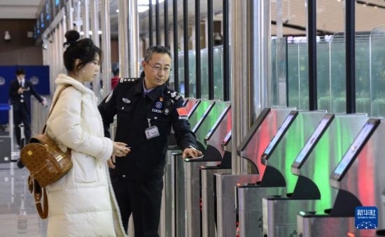 1月2日，大興機(jī)場(chǎng)邊檢站警察指導(dǎo)旅客使用自助出境設(shè)備。新華社記者 李欣 攝