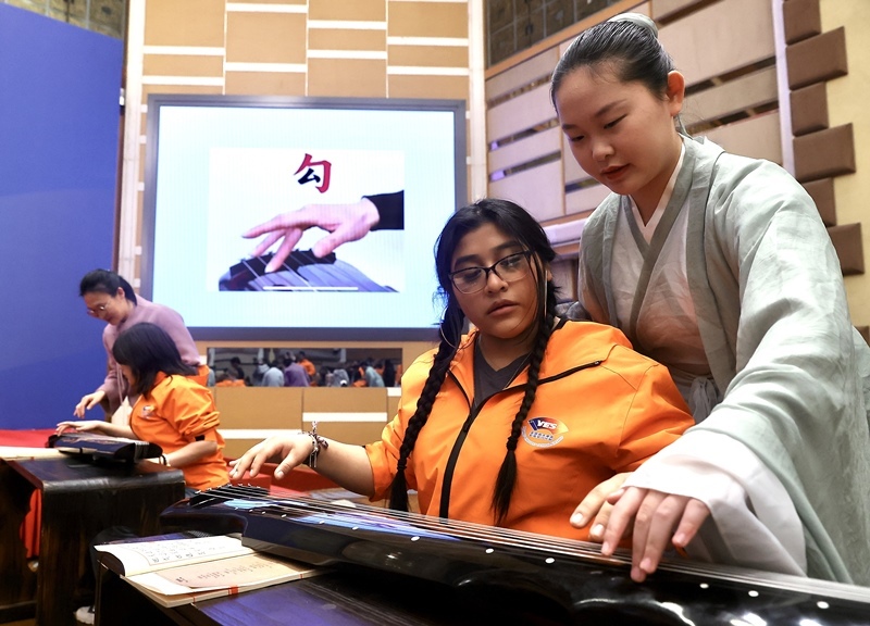 2024年3月20日，美國華盛頓州中學生代表團北京大學交流活動在北京大學英杰交流中心舉行。圖為來自華盛頓州的中學生體驗古琴。