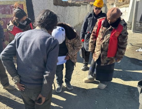 1月13日，次旺（右一）陪同工作組走訪村莊，評估房屋受損程度。新華社發(fā)