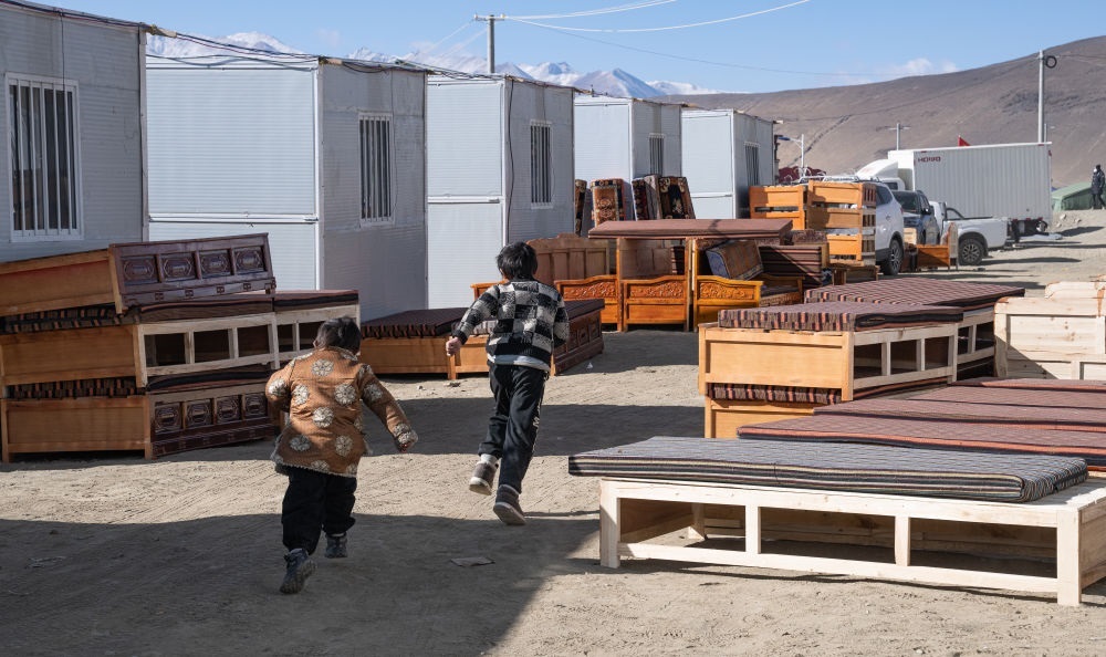 2025年1月13日，在定日縣嘎旦村，兩個孩子在剛運來的兩排藏床間奔跑。新華社記者丁增尼達 攝