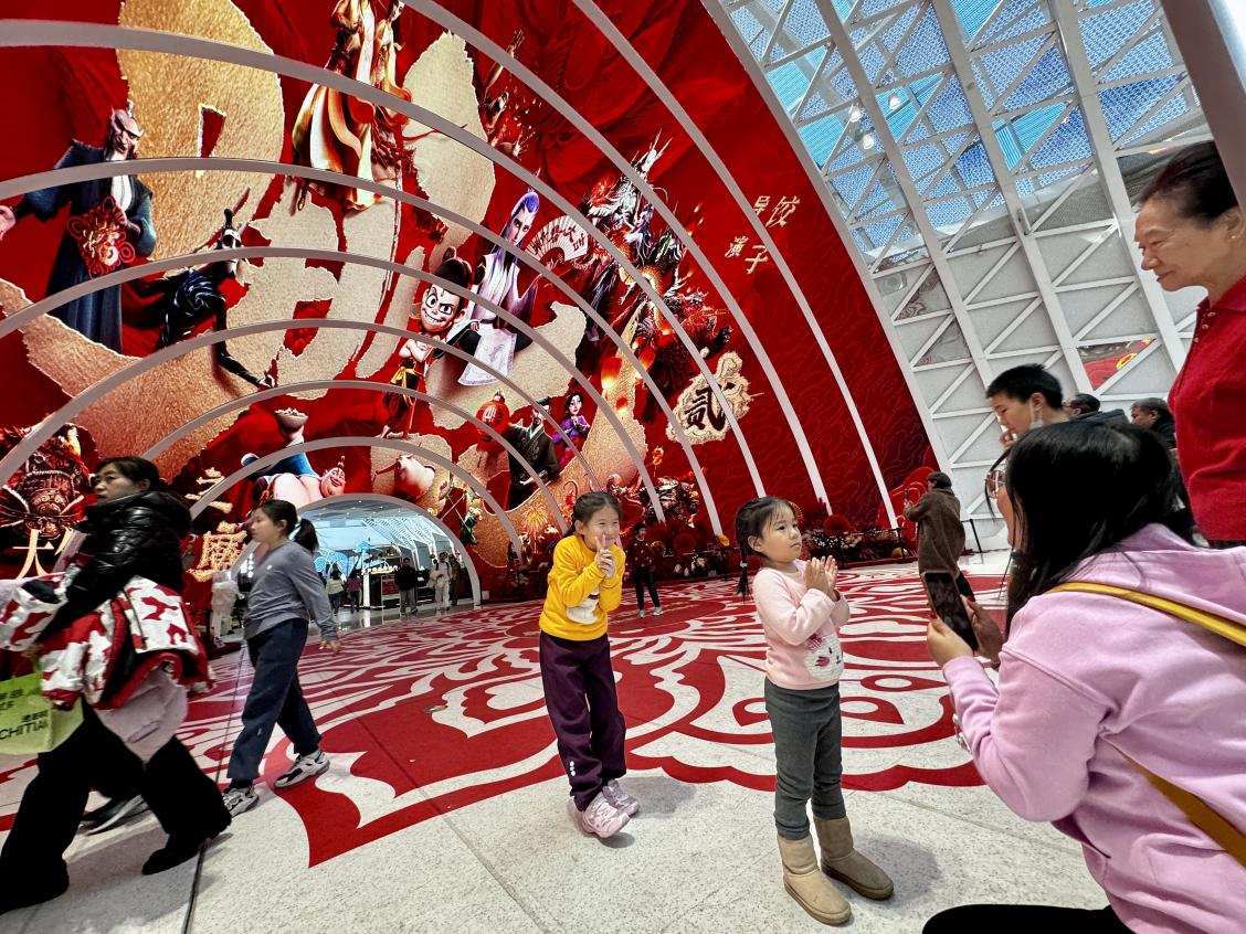 乙巳蛇年春節(jié)期間，影迷在《哪吒之魔童鬧海》巨幅海報(bào)前拍照打卡。