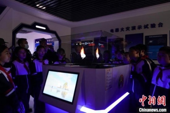 圖為學生們參觀道里區(qū)消防救援大隊消防科普體驗館內(nèi)幻影成像燃燒三要素實驗臺。中新社記者 趙宇航 攝