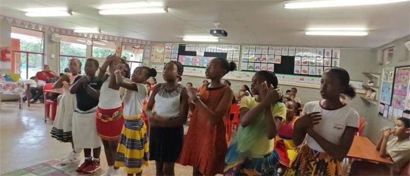 南非學(xué)生展示民族服飾，合唱《聽我說謝謝你》。