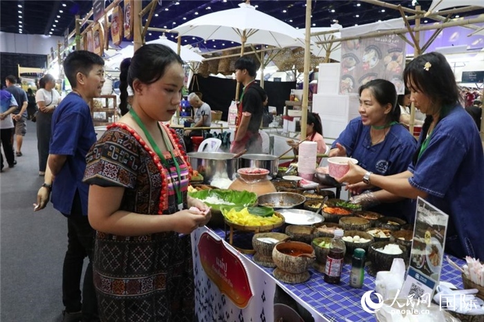游客在攤位前購(gòu)買(mǎi)特色美食。朱瀟逸攝