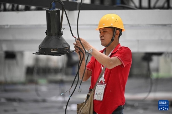 4月4日，工作人員在海南國(guó)際會(huì)展中心內(nèi)布設(shè)燈光。